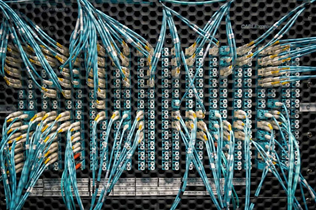 Teal fiber optic cables on panel board