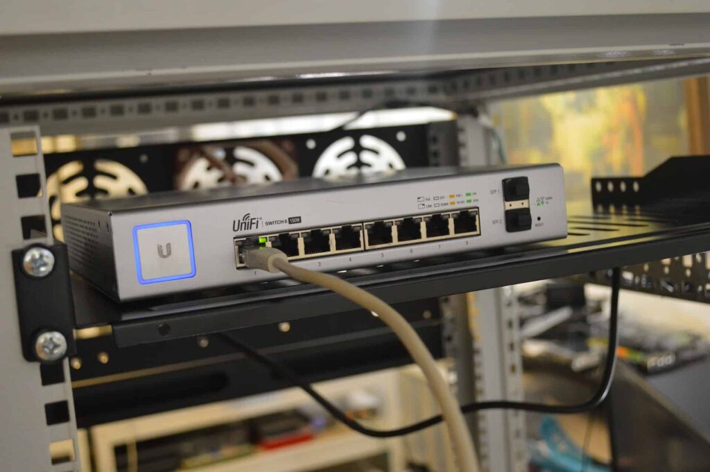 White ethernet cables plugged in a unifi modem
