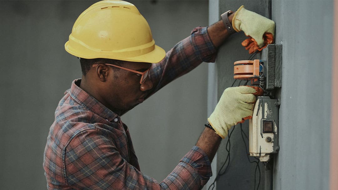 Data Center Power Technician Fixing Outside Electrical Wiring