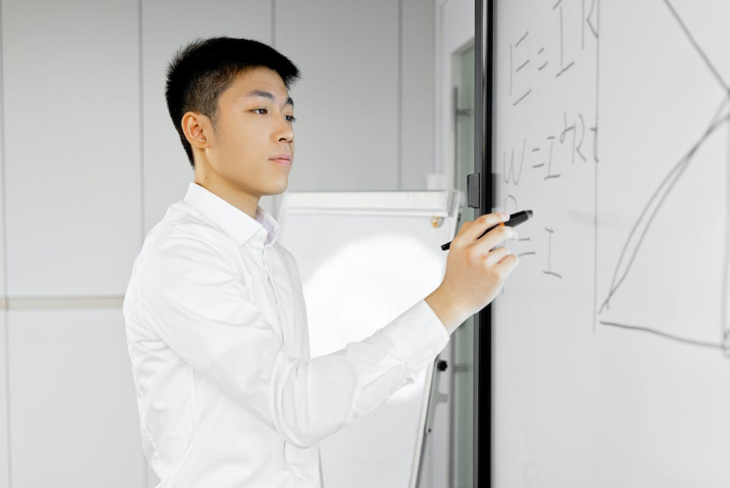 A man writing on a smartboard