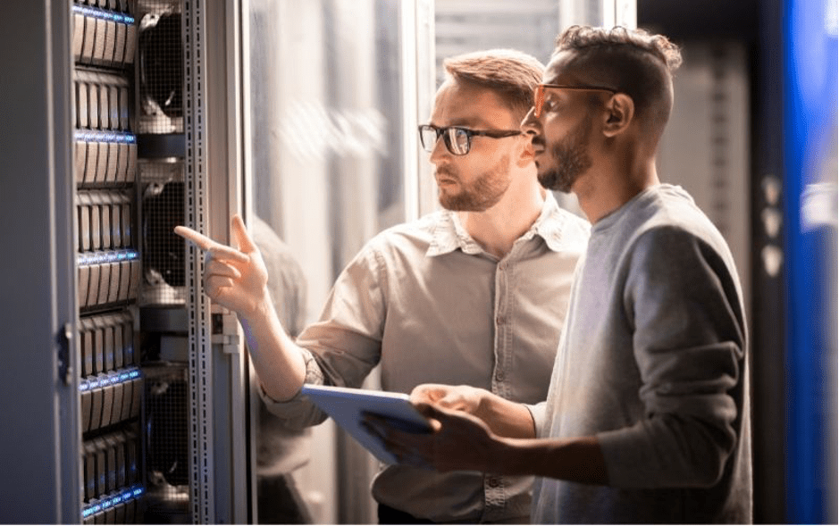 Two guys looking at the server cabinet