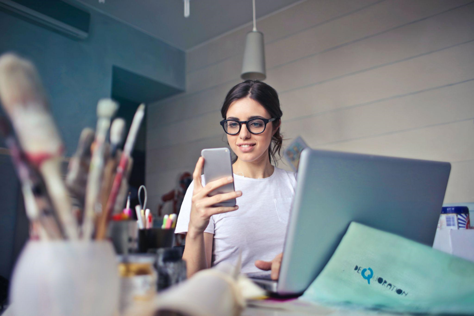 A girl using her phone and laptop